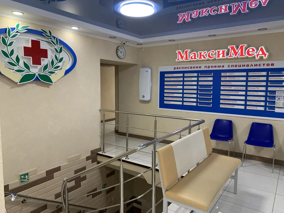 Холл «МаксиМед» с логотипом центра и местами для ожидания